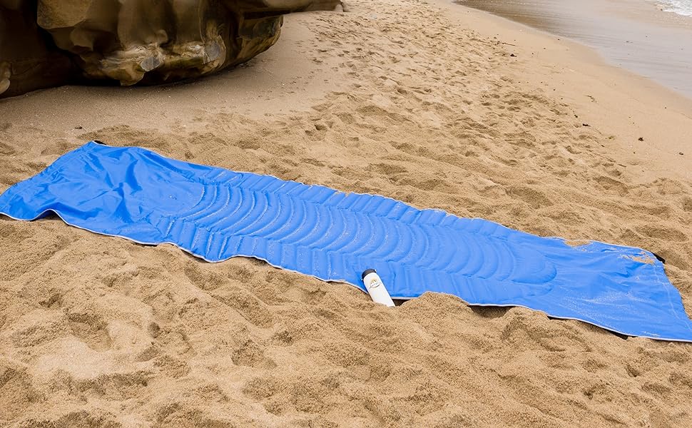 HangPad being used as a beach blanket.