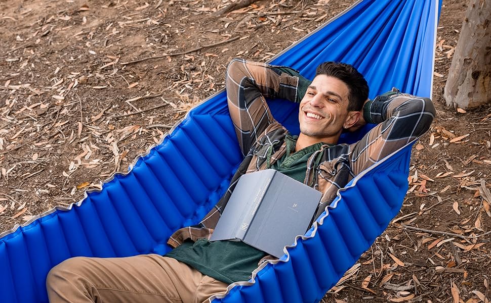 Man Relaxing in a HangPad hammock with a book resting on his chest.
